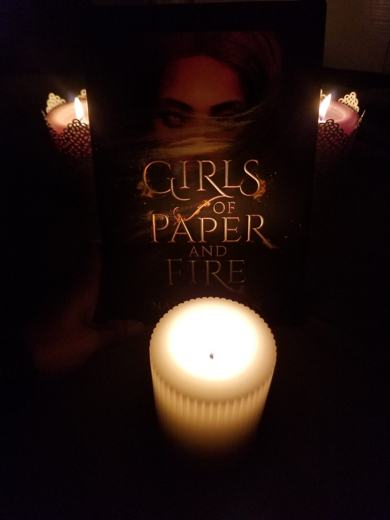 Novel GIRLS OF PAPER AND FIRE surrounded by three candles