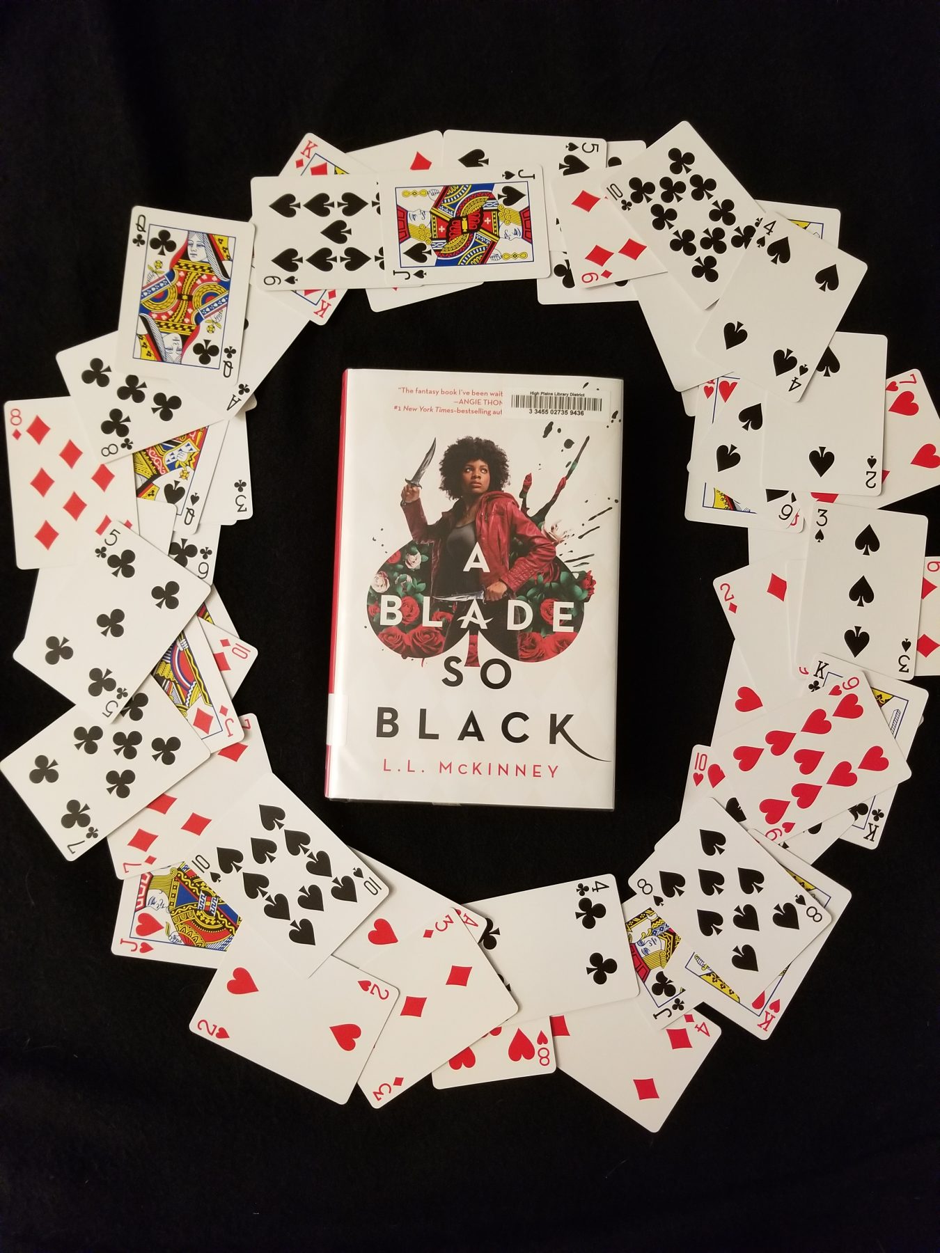 Novel A BLADE SO BLACK surrounded by a circle of playing cards