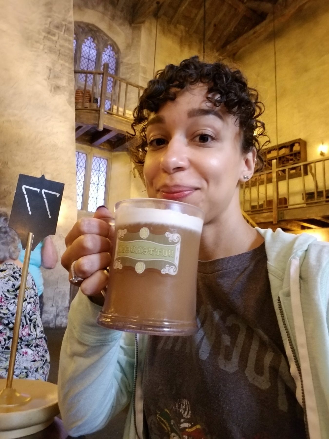 Jessie holding a mug of butterbeer