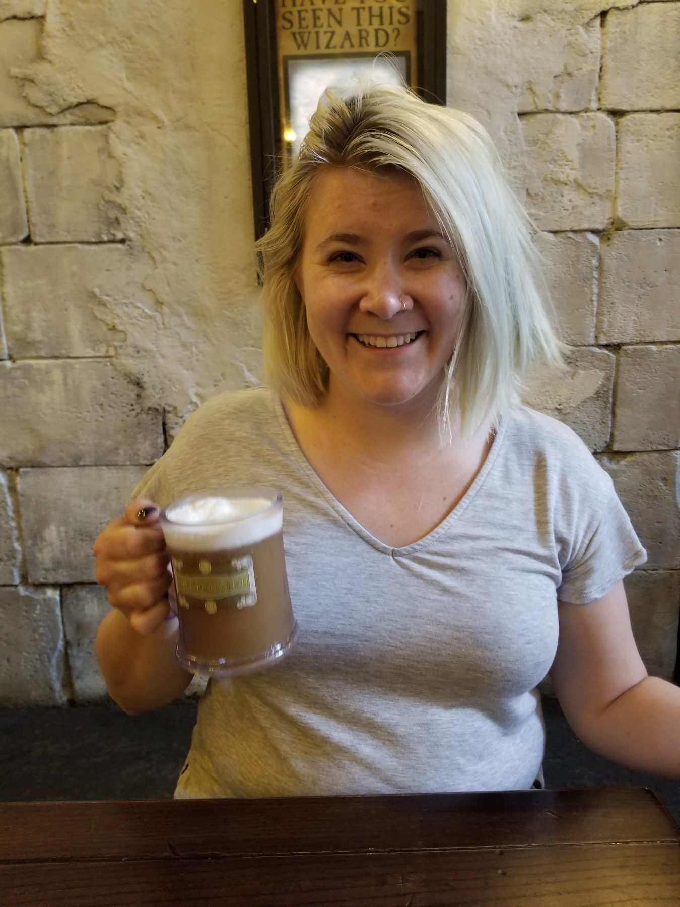 Kelly smiles with a mug of butter beer in her hand