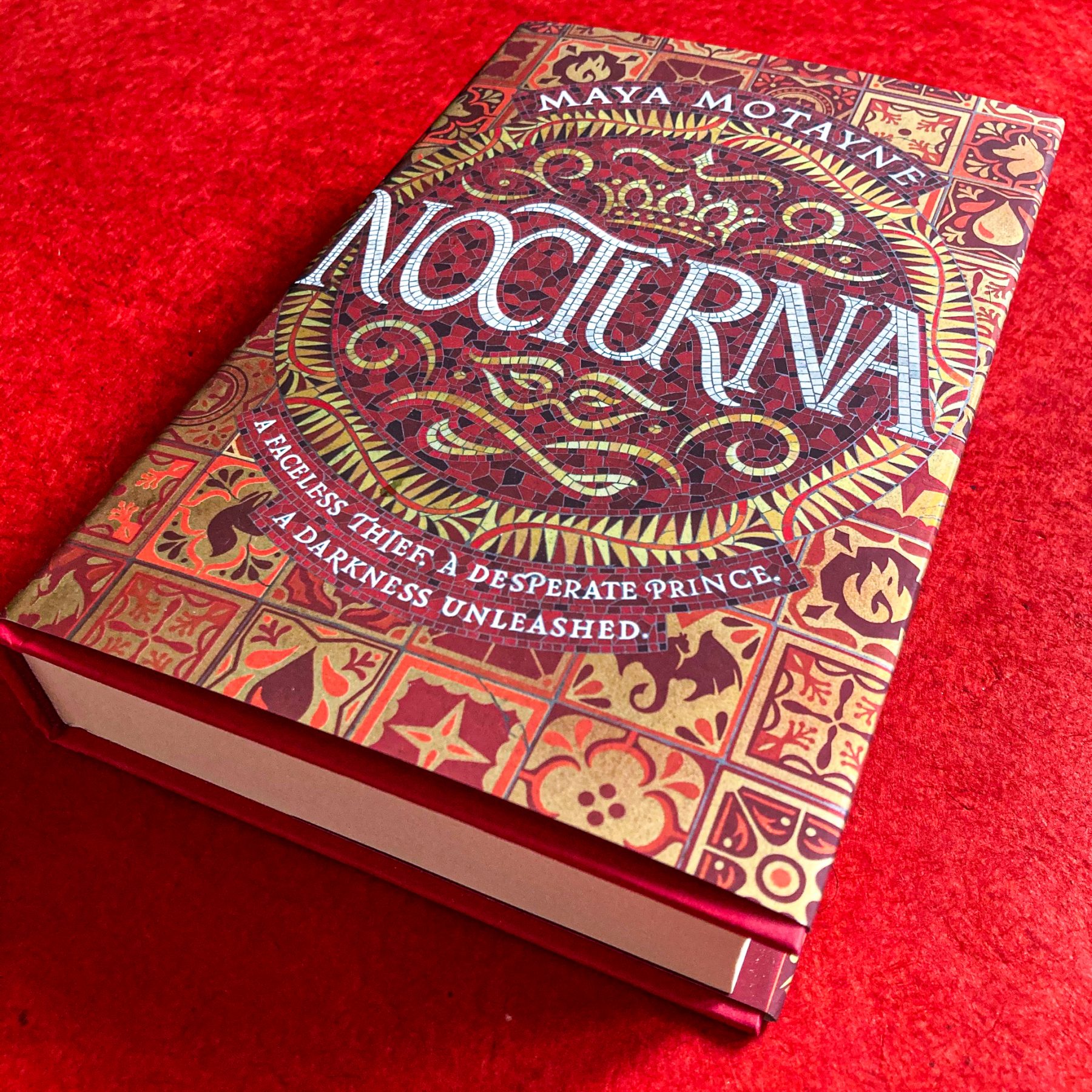 Hardcover version of Nocturna sit on a bright red background