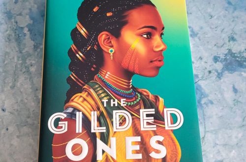 book, The Gilded Ones by Namina Forna on a blueish grey background