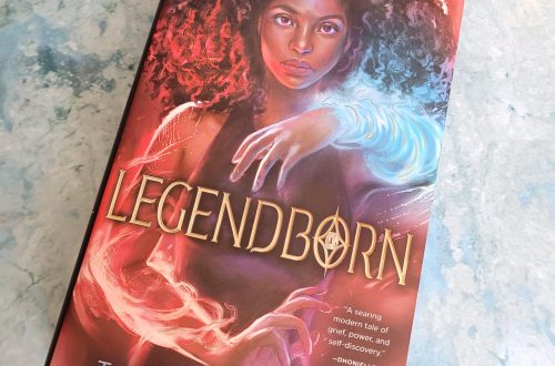 book, Legendborn, on a grayish blue background with fairy lights at the top and bottom