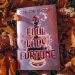 A pink metallic hardcover copy of Foul Lady Fortune rests on yellow and orange fallen leaves.